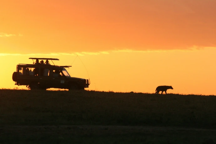 silhouette of SUV under orange sky